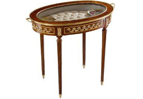 An elegant French Louis XVI style ormolu-mounted oval shape bijouterie / vitrine table, The oval removable tray top ornamented with ormolu handles and ormolu strip, upholstered inside in tufting / capitone style above a frieze ormolu mounted with foliate garlands and rosettes. Raised on a fluted tapered legs with ormolu sabots